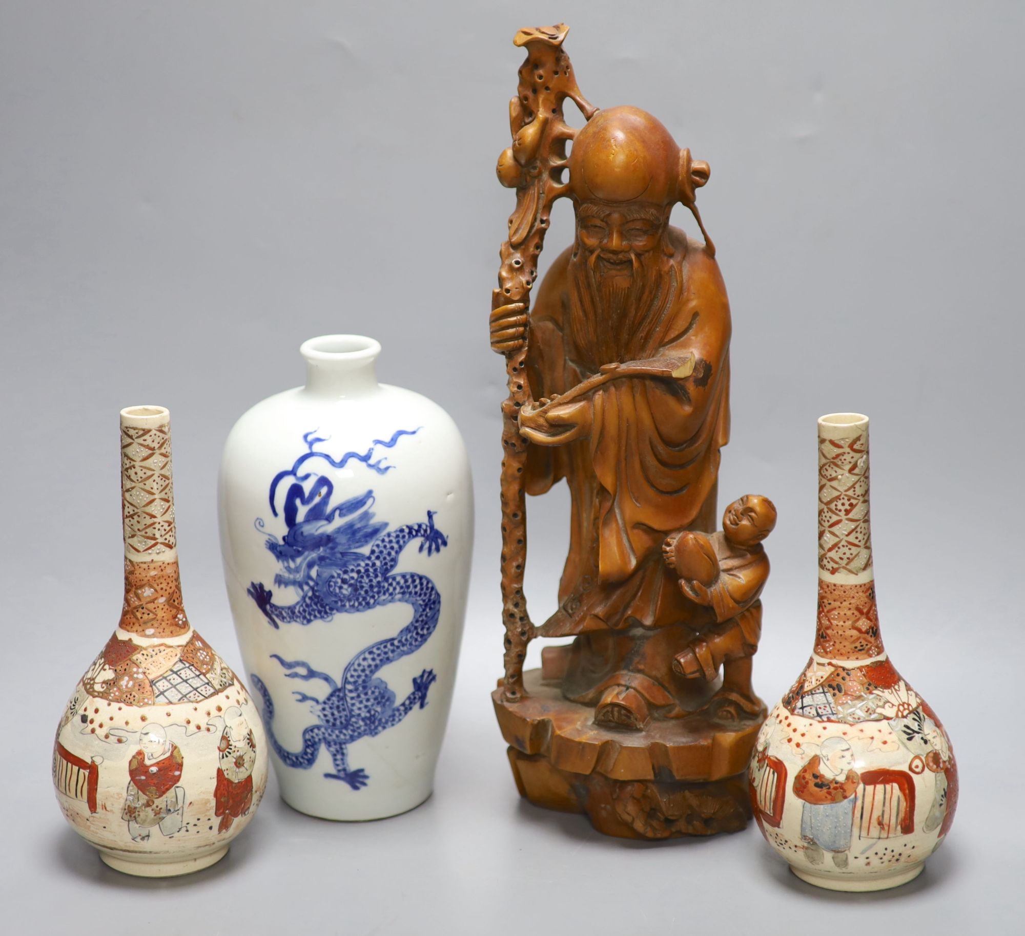 A pair of Satsuma bottle vases, a Chinese blue and white dragon vase, 22cm, and a hardwood carving of Shou Lao, height 37cm